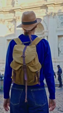  Şapkalı ve sırt çantalı bir kadın turist Trevi Çeşmesi 'nin önüne geliyor. Roma, İtalya 'yı gezen güzel kadın, 29.04.2025.