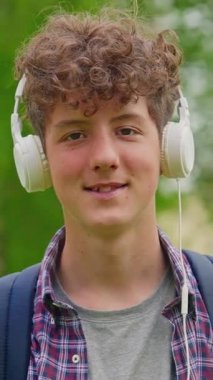 Dikey video. Kulaklıklı mutlu genç kız portresi..