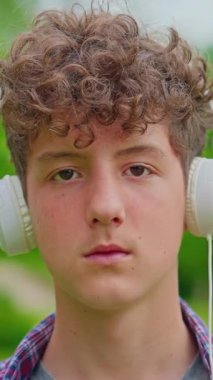 Dikey video. Kulaklıkla dans eden mutlu genç kızın portresi..