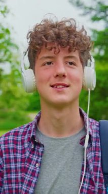 Dikey video. Kulaklıkla dans eden mutlu genç kızın portresi..