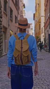 Roma, İtalya 'da sırt çantalı bir kadın turist eski bir caddede yürüyor. Roma 'nın eski şehrine bakan bir kız..