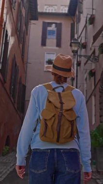 Roma, İtalya 'da sırt çantalı bir kadın turist eski bir caddede yürüyor. Roma 'nın eski şehrine bakan bir kız..