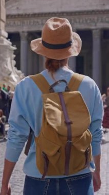 Şapkalı ve sırt çantalı bir turist kız eski Roma şehrinin etrafında ünlü antik Pantheon 'un yanında ve yakınındaki meydanda yürüyor. Pantheon cephesi. Roma, İtalya, 12.04.2025.