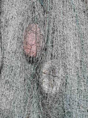 Two floats that are nestled in a tangled fishing net result in a soft background image.