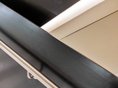 Merdivendeki tırabzanların soyut bir görüntüsü geometrik bir tasarımı gösterir