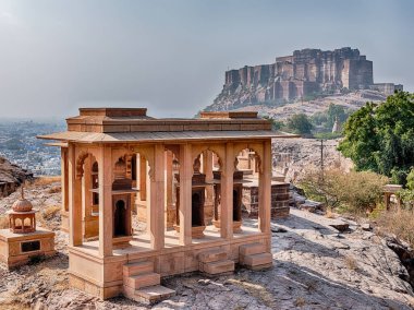 Jodhpur 'daki Jaswant Thada anıtının bahçesinde bir yakma anıtı duruyor. Arka planda, Mehrangarh kalesi şehri dağın tepesinden korur..