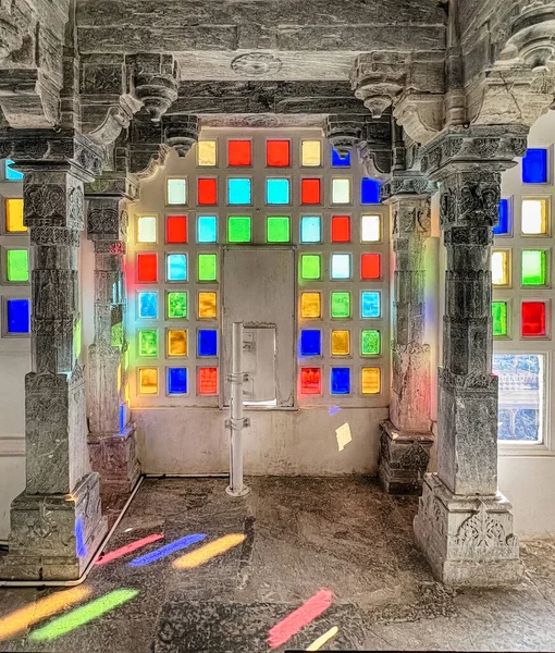 stock image Sunlight coming in through brightly colored glass illuminates an empty room in the City Palace of Udaipur.