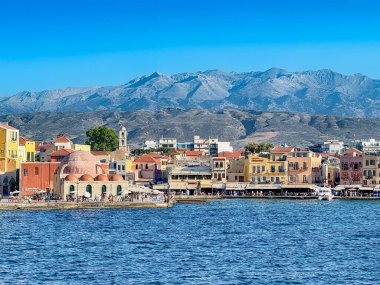 Scenic view of the main harbor at Chania with the mountains of Crete in the background. clipart