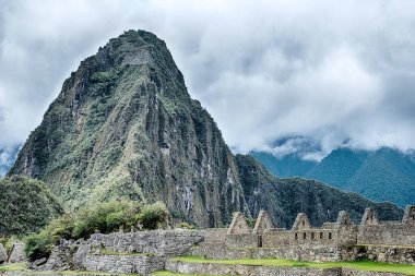 Huayna Picchu 'nun küçük dağı ön planda Machu Picchu' nun sözde kraliyet sarayının üzerine çöker..