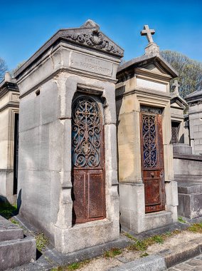 PARIS, FRANCE - 5 Nisan 2023: Paris 'teki Pere Lachaise Mezarlığı' nda iki aile mahzeni yan yana duruyor.