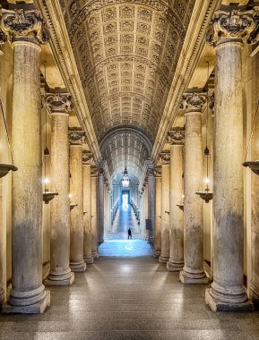 İsimsiz bir adam Vatikan 'ın neredeyse boş koridorlarında uzun bir merdivenin dibinde yürüyor..