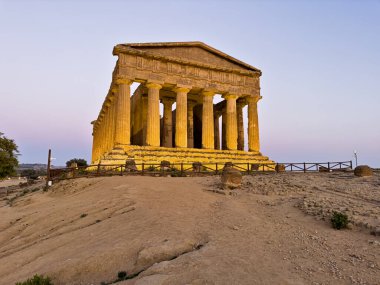 The ancient Roman and Greek Temple Of Concordia is illuminated at night in the Valley Of The Temples near Agrigento, Sicily. clipart