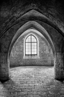 Çek Cumhuriyeti 'nin Kutna Hora kasabasındaki Corpus Christi Şapeli' nin mahzenlerini aydınlatmak için pencere ışığı içeri giriyor. Siyah ve beyaz..