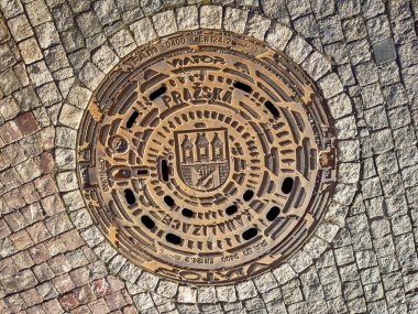 Yuvarlak demir rögar kapağı Prag 'ın sembolü olan üç kulenin sembolünü gösteriyor..