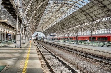 Prag 'daki Woodrow Wilson tren istasyonundaki neredeyse boş demiryolu platformunda birkaç isimsiz gezgin rayların üzerinde duruyor..