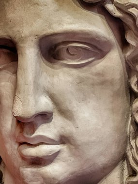 Tanımlanamayan bir heykelin ayrıntıları gözlerdeki gölgeleri ve güçlü bir burnu vurgular..
