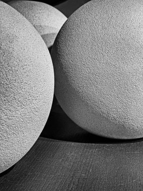 Raftaki birkaç kil topun üzerine düşen ışık ve gölgelerin soyut görüntüsü. Siyah ve beyaz..