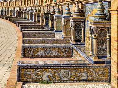 İspanya 'nın Sevilla kentindeki Plaza de Espana' daki ana binanın tabanında İspanya 'nın bir bölgesinden gelen kitapları tutmak için dizayn edilmiş bu dizi İl Koy' ları bulunuyor..