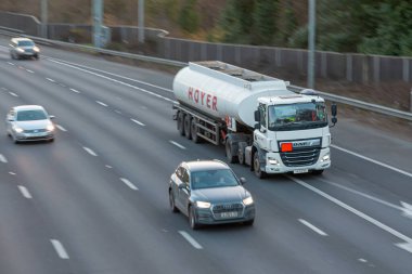 Chorleywood, UK - February 25, 2023: Tanker lorry belonging to Hoyer,  world market leader in handling and transporting liquid products traveling on the British motorway M25.