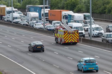 Londra, İngiltere - 14 Haziran 2023: Meşgul İngiliz otoyolu M25 üzerinde hareket eden itfaiye aracı