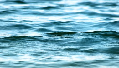 Güzel turkuaz suların yüzeyinde hareket eden yumuşak dalgaları kapatın. 