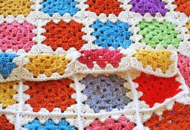 Parlak ve renkli büyükanne kareleri kullanarak el yapımı örgü örülü battaniye.