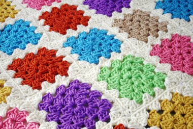 Parlak ve renkli büyükanne kareleri kullanarak el yapımı örgü örülü battaniye.