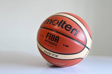 SINGAPORE - 16 Aralık 2022: Erimiş bir basketbol topunu yere yakın tut.