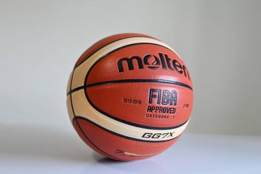 SINGAPORE - 16 Aralık 2022: Erimiş bir basketbol topunu yere yakın tut.