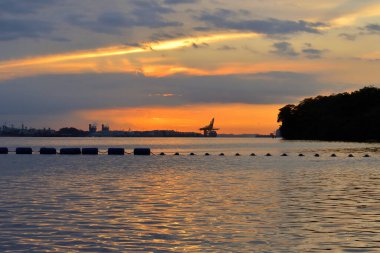 Kumsalda bulutlu gökyüzü ile güzel bir gün doğumu.