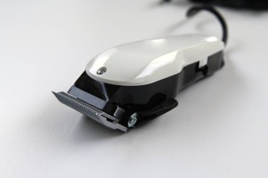 Beyaz arkaplanda izole edilmiş elektrikli saç makasını kapat, seçici odak.