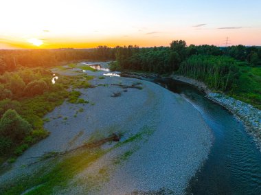 Kayalık nehrin üzerinde güzel bir gün batımı, dağ nehri. 4K 'da bir ormanın ortasında kayalık bir nehir. Gökyüzünü yansıtan sakin nehrin havadan görünüşü, yemyeşil arazi, hava manzarası