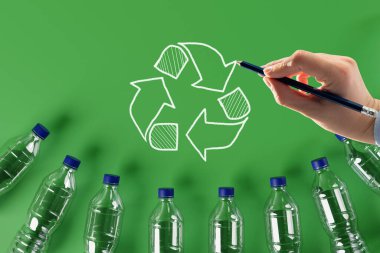 Geri dönüşüm ikonlu plastik şişeler ve boyalı geri dönüşüm okları. Doğa ve çevre koruma kavramı. Plastik geri dönüşümü.