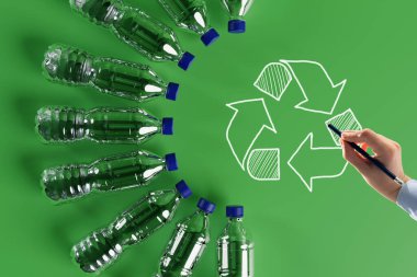 Geri dönüşüm ikonlu plastik şişeler ve boyalı geri dönüşüm okları. Doğa ve çevre koruma kavramı. Plastik geri dönüşümü.