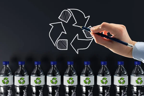 Plastic bottles with the recycling icon and painted recycling arrows. Concept of nature and environment protection. Plastic recycling.