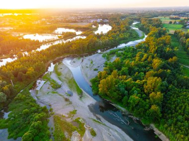 Ormanın ortasında kayalık bir nehir. Gökyüzünü yansıtan sakin nehrin havadan görünüşü, yemyeşil bir manzara, hava manzarası. Ormandaki bir dağ nehri manzarası.