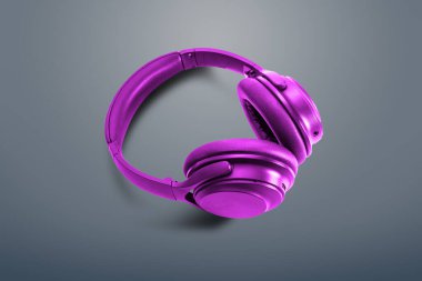 Bilgisayar kulaklıkları. Koyu gri arka planda mor kulaklıklar. Müzik dinleme, ses yaratma, müzik konsepti. Bilgisayar işi, soyutlama ve minimalist stil.