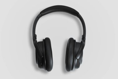 Bilgisayar kulaklıkları. Beyaz arka planda siyah kulaklıklar. Müzik dinleme, ses yaratma, müzik konsepti. Bilgisayar işi, soyutlama ve minimalist stil.