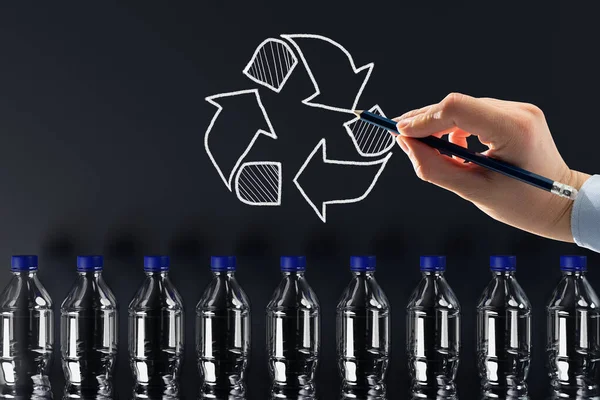 Plastic bottles with the recycling icon and painted recycling arrows. Concept of nature and environment protection. Plastic recycling.