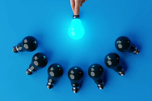 手は他の消滅電球の背景に電球を保持しています アイデアや創造性の出現という概念は — ストック写真