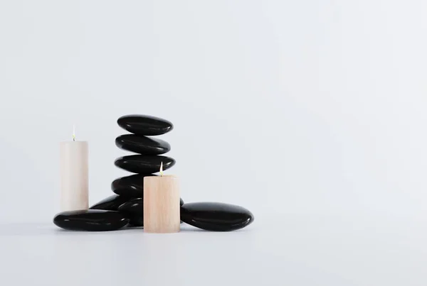 黑色按摩石和蜡烛在浅色背景上 按摩的概念 Spa和美容护理 3D渲染 3D插图 — 图库照片