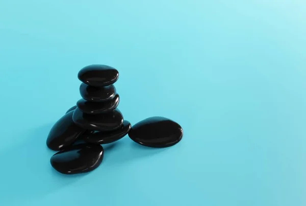 蓝色背景上的黑色按摩石 按摩的概念 Spa和美容护理 3D渲染 3D插图 — 图库照片