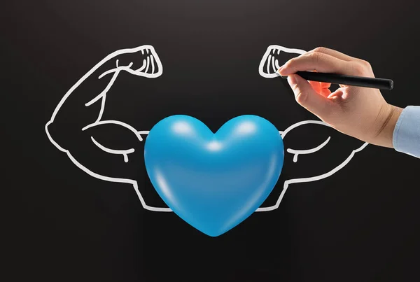 Heart on the background of drawn by hand muscles. The concept of a strong and healthy heart, taking care of your physical condition.
