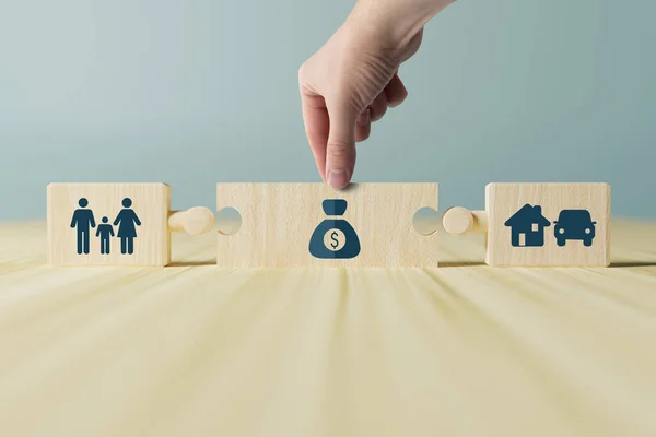 Wooden blocks with icons of family, money and car, home. The concept of a family buying a house, a car. Starting a family and finances for this purpose.