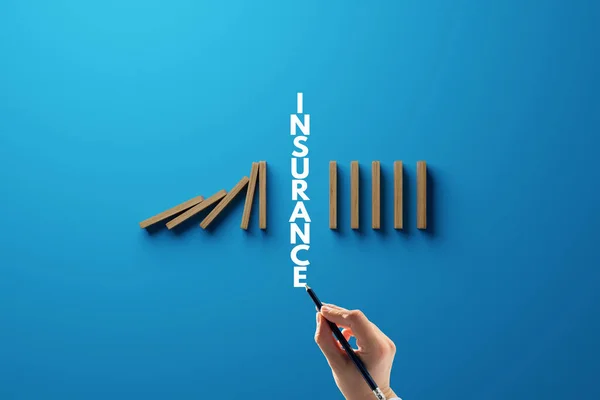 Falling dominoes, interrupted by the inscription INSURANCE. The concept of insurance, safety for people and personal goods, collapse protection.