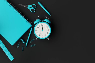 Okul malzemeleri, defter, kalemler, çalar saat. Okula dönme, öğrenme kavramı. Öğrenciler öğreniyor. Koyu bir arka planda mavi okul eşyaları. 3d görüntüleme, 3d illüstrasyon.