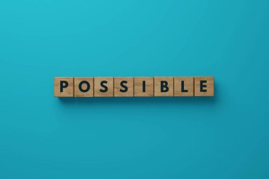 Wooden blocks on a blue background with the word Possible. The concept of success in life, business. 3d render