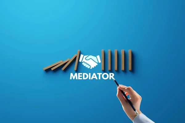Dominoes falling over, stopped by hand and mediator. The concept of mediation and the use of mediator services. Mediation help for people in problems.