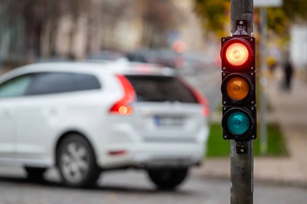 stock image blurred view of city traffic with traffic lights, in the foreground a semaphore with a red light