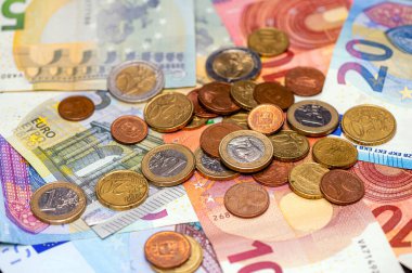 background of banknotes and euro coins of different denominations close-up